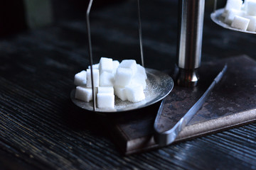 Sugar cubes on the scales in a cafe on the table