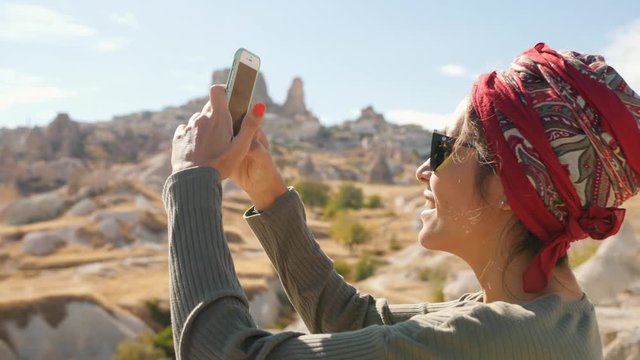 Young Mixed Race Tourist Girl Takes Photos of Desert Valley Using Mobile Phone. Cappadocia, Turkey. 4K.