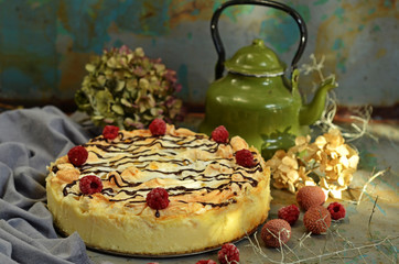Cheesecake with pineapple and raspberries with chocolate topping on a wooden background
