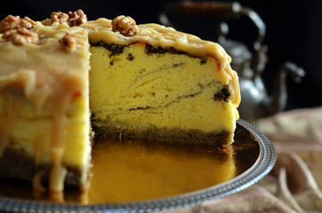 Cheesecake with glaze and nuts on a gold placemat