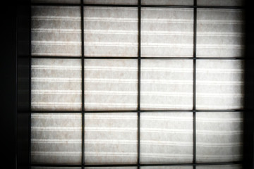 metal grill, cloth behind the grill, dark background, striped fabric