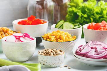 Assortment ingredients for healthy vegetarian salad in different portion bowls on a table. The concept of fitness and vegan food.