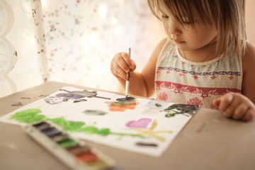 European child paints with watercolors, lifestyle