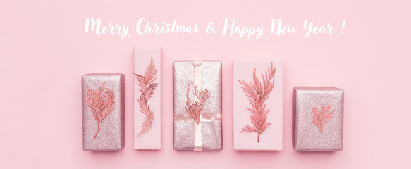 Gift wrapping banner. Pink nordic christmas gifts isolated on pastel pink background. Wrapped xmas...