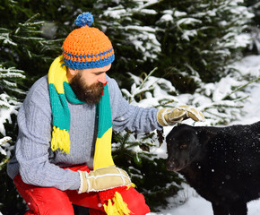 Macho with beard and mustache pats dog.