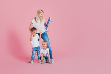 Beautiful blonde mom with two happy sons. Young woman and two baby boys