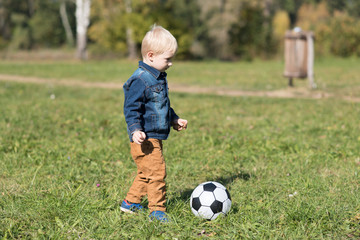 Little child play football in the park