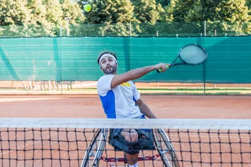 Fototapeten disabled tennis player hits the ball backhand © Marino Bocelli