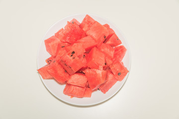 a close-up, on a plate are pieces of sliced watermelon