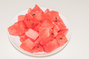 a close-up, on a plate are pieces of sliced watermelon