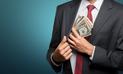 Pocketing company money. businessman placing money into