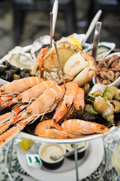 Plate with fresh assorted seafood in french summer restaurant. Close up image