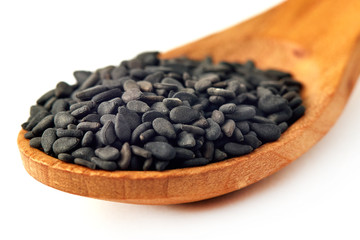 Fototapeta na wymiar Black sesame seeds in wooden spoon isolated on white background
