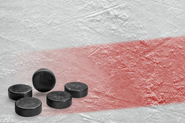 Pucks and ice rink fragment with a red line