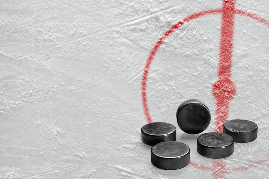 Pucks and a fragment of the hockey arena with a central circle