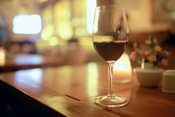 red wine glass serving / romantic dinner in the interior of the restaurant, a table served with a glass of grapes wine