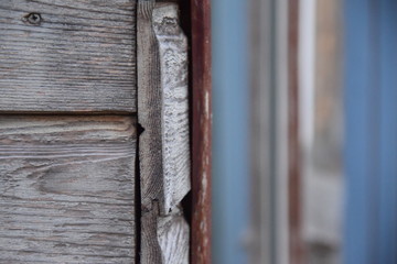 Vermoderte, hölzerne Fassade einer alten Hütte in einem Garten