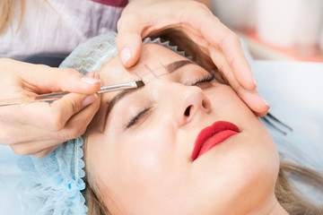 Obraz na płótnie Canvas Correction of eyebrows in the beauty salon 