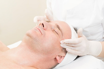 Man in the mask cosmetic procedure in spa salon. 
