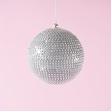 Silver Shiny Christmas Bauble Decoration On Pastel Pink Background. New Year Party Background. Minimal Style.