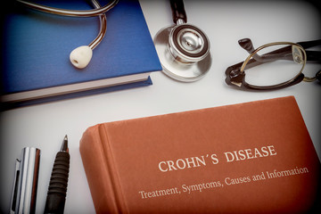  Titled book Crohn's Disease along with medical equipment, conceptual image