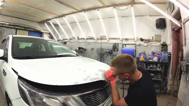 young man repairs cars in the garage.