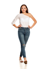 Obraz premium young beautiful girl in jeans walking on white backgeound