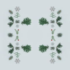 Creative layout made with evergreen tree branches on bright background with snowflakes. Christmas minimal background.