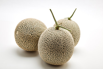 Three cantaloupe melon on white