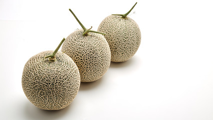 Three cantaloupe melon on white