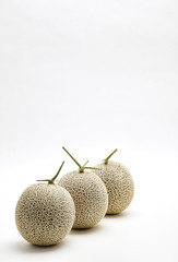 Three cantaloupe melon on white