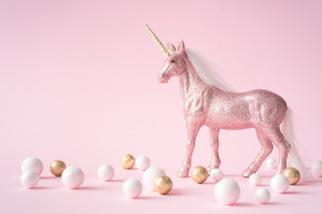 Pink glitter unicorn with gold and white decoration.Magic surreal style. Minimal composition.