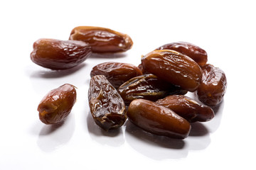 Close-up of pile dried, raw dates on white background