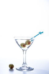 Martini cocktail liquor drink with the pickled olive isolated on white background