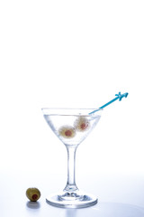 Cold Martini cocktail liquor drink with the pickled olive isolated on white background