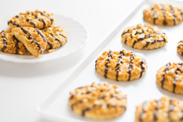 Shortbread cookies with nuts and chocolate on a plate and tray