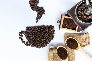 coffee beans in coffee cup shaped with wooden grinder and sack