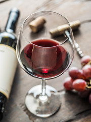 Wine glass, wine bottle and grapes on wooden background. Wine tasting.