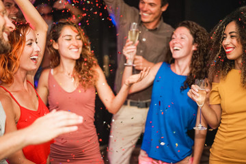 Young people dancing and driking champagne at weekend party night