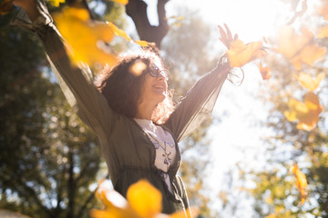 love, relationship, family and people concept - smiling woman in the autumn park among the yellow leaves