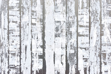 Close-up of vertical strips of white torn paper on a light gray metal background	