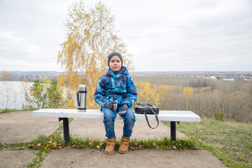 boy sits on a bench and drinks tea © vitec40