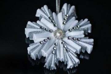 Silver decorative snowflakes on a black background. Christmas greeting card. Top view. Handmade. Kanzashi snowflake. Copy space.