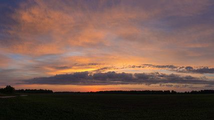 Fototapeta premium Dawn over the field, the sun's rays penetrate the clouds