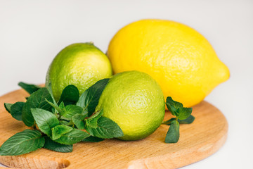 lemon, lime and mint on a wooden board 