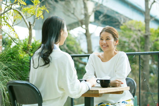 テラス席に座り話す女性2人