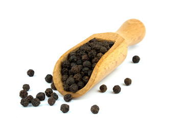 Black pepper on wooden scoop isolated on white background