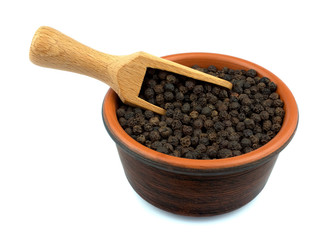 Black pepper in the bowl isolated on white background with a woo