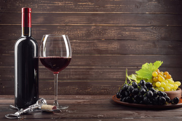 Fototapeta na wymiar Wine bottle and grape on wooden table