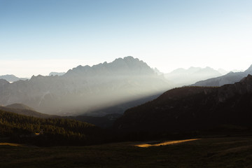 First ray of light over a misty morning in the Dolomites Italy